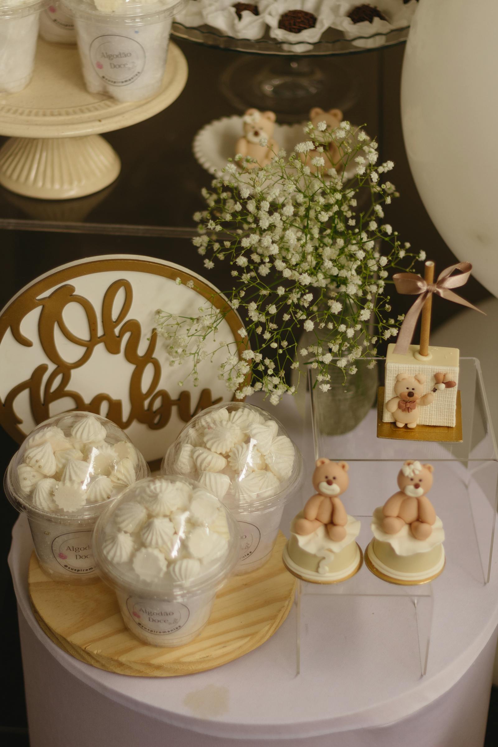 Baby shower dessert table with Oh Baby sign, meringues, and teddy bears