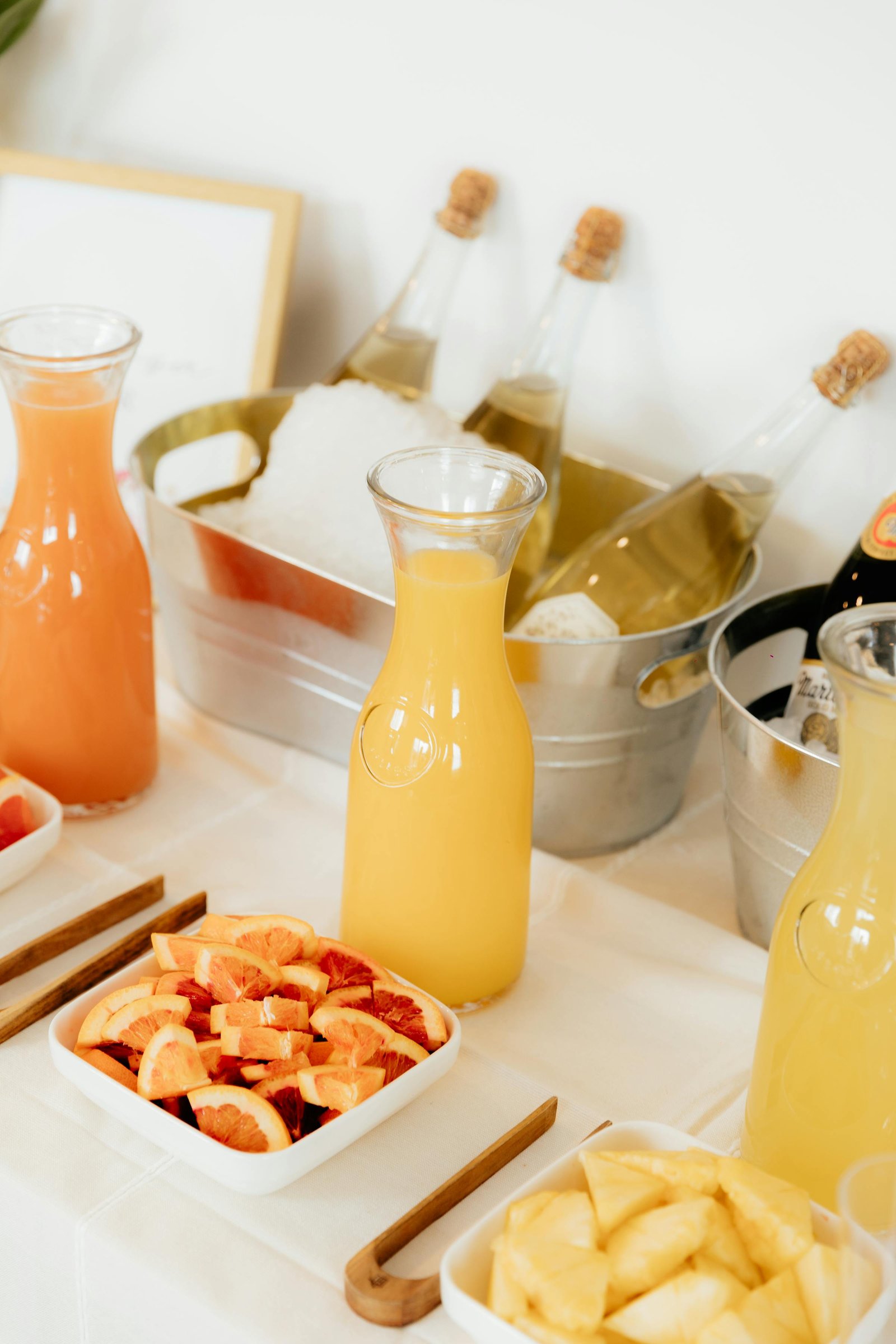 DIY mimosa bar with juices fresh oranges and champagne in ice bucket