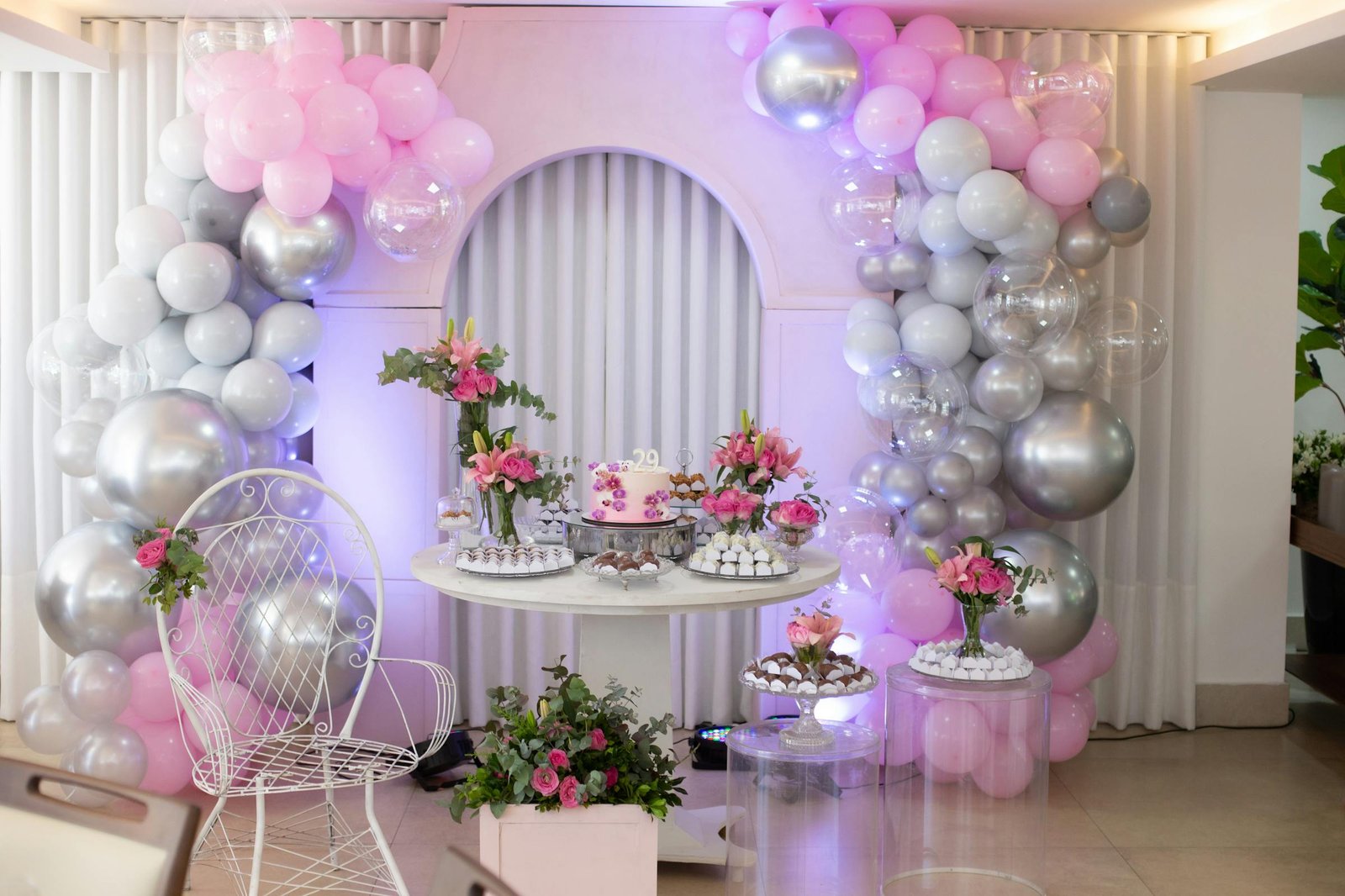 Pink and silver balloon arch with dessert table for bachelorette party